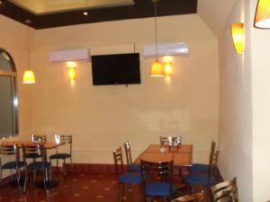 une salle à manger avec des tables et des chaises et une télévision à écran plat dans l'établissement Hotel San Jose, à Mérida