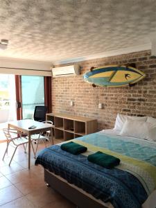 1 dormitorio con 1 cama con tabla de surf en la pared en Byron Beach House, en Byron Bay