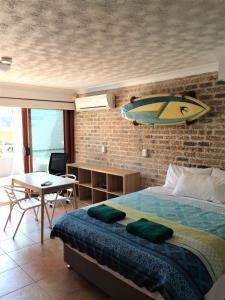 een slaapkamer met een bed met een surfplank aan de muur bij Byron Beach House in Byron Bay