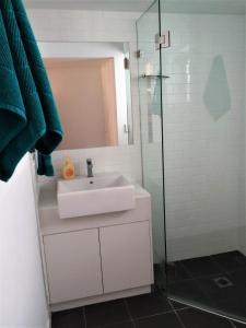 een badkamer met een wastafel en een glazen douche bij Byron Beach House in Byron Bay