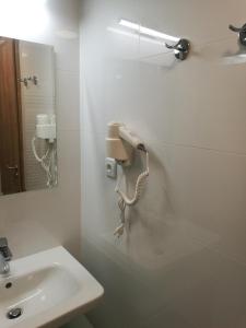 uma casa de banho com um telefone na parede ao lado de um lavatório em Apartmány Sport Dolní Morava em Dolní Morava
