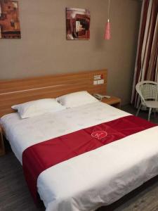 Una cama grande con una manta roja y blanca. en Thank Inn Chain Hotel Jiangsu Yixing Dingshu Town East Jiefang Road en Zhoushu