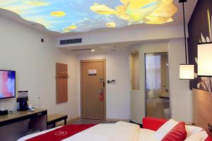 1 dormitorio con 1 cama y techo con un pez pintado. en Thank Inn Plus Hotel Shandong Daminghu en Jinan