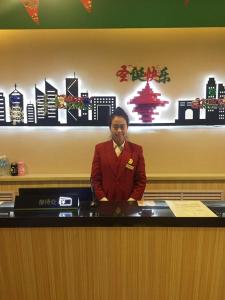 una mujer de pie en un escritorio en una oficina en Thank Inn Chain Hotel Hebei Zhangjiakou Xuanhua District People Park, en Zhangjiakou