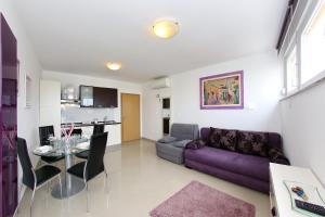 sala de estar con sofá púrpura y mesa en Town Center Apartments, en Zadar