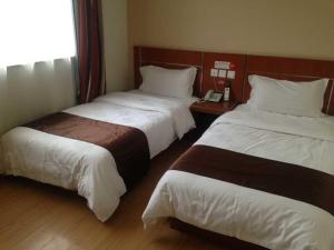 Habitación de hotel con 2 camas y teléfono en Thank Inn Chain Hotel Hebei Langfang Guan Bus Station, en Liuquan