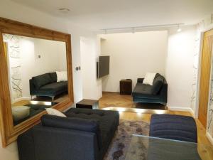 - un salon avec un canapé et un miroir dans l'établissement Modern 1 Bedroom Apartment in Kensington, à Londres