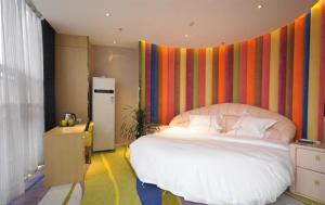 1 dormitorio con 1 cama grande y pared colorida en JUNYI Hotel Hebei Xingtai Qinghe West Wusong Road, en Xielu