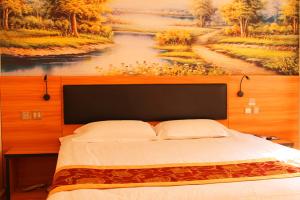 1 dormitorio con 1 cama con una pintura en la pared en Thank Inn Chain Hotel Shandong Heze Yuncheng County Ximen Street Shuichu Haohan City en Yuncheng