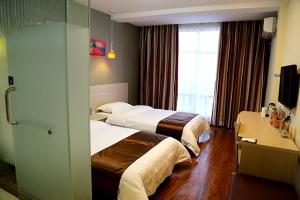 a hotel room with two beds and a desk at Thank Inn Chain Hotel Liaoning Anshan Haicheng Wanda in Yanjun