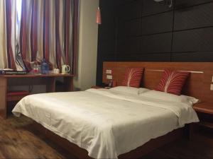 a bedroom with a large white bed with red pillows at Thank Inn Chain Hotel Shangxi Changzhi Daqing Road in Changzhi