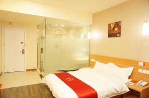 Thank Inn Chain Hotel Hunan Loudi New Huaxuefu Road في Dongling: غرفة نوم بسرير كبير ودش زجاجي