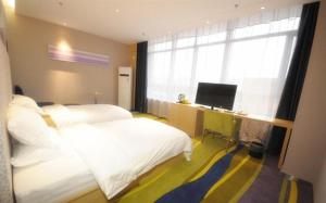 1 dormitorio con 2 camas y escritorio con ordenador en JUNYI Hotel Hebei Xingtai Qinghe West Wusong Road, en Xielu
