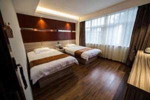 a hotel room with two beds and a window at JUNYI Hotel Jiangsu Yancheng Tinghu District Jinying International Shopping Center in Yancheng +3 photos
