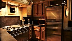 a kitchen with wooden cabinets and a stainless steel refrigerator at Chalet Geneviève in Sainte-Foy-Tarentaise +28 photos