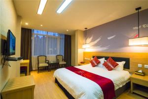 a hotel room with a large bed and a table at Thank Inn Chain Hotel Sichuan Guangan Wusheng County Hongwu Avenue in Wusheng