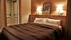 a bedroom with a bed with two lamps on the wall at Chalet Geneviève in Sainte-Foy-Tarentaise