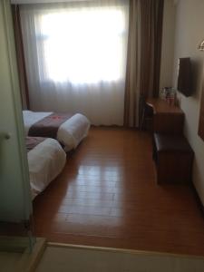 um quarto de hotel com duas camas e uma janela em Thank Inn Chain Hotel Hebei Langfang the 6th Street em Langfang