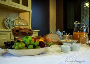 una mesa con un tazón de fruta y un tazón de pan en La Corte di Alzo, en Pella