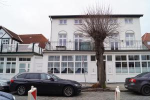 a black car parked in front of a white building at Apartments in Warnemuende in Warnemünde