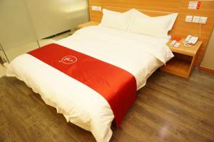 Thank Inn Chain Hotel Hunan Loudi New Huaxuefu Road في Dongling: غرفة فندق بسرير وبطانية حمراء وبيضاء