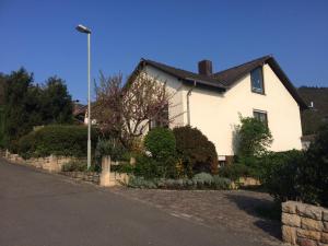 une maison blanche avec un éclairage de rue devant elle dans l'établissement schones Zimmer in Gimmeldingen/ Konigsbach, à Neustadt an der Weinstraße