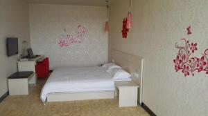 um quarto com uma cama branca e uma parede vermelha em Thank Inn Chain Hotel Hebei Shijiazhuang Lingshou Town Wanhao em Xituo