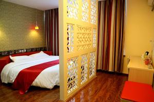 una camera con un letto con una coperta rossa e bianca di Thank Inn Chain Hotel Liaoning Anshan Haicheng Wanda a Yanjun
