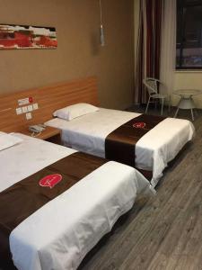 Habitación de hotel con 3 camas y mesa en Thank Inn Chain Hotel Jiangsu Yixing Dingshu Town East Jiefang Road en Zhoushu