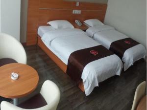 Habitación de hotel con 2 camas y mesa en Thank Inn Chain Hotel Shanxi Lvliang Lishi Beichuanghe Road, en Luliang
