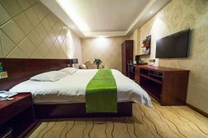 um quarto com uma cama grande e uma televisão em JUNYI Hotel Jiangsu Yancheng Tinghu District Jinying International Shopping Center em Yancheng