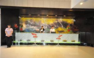 a man standing in front of a counter in a restaurant at JUNYI Hotel Hebei Xingtai Qinghe West Wusong Road in Xielu