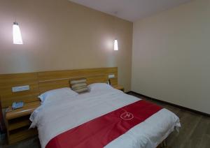 Schlafzimmer mit einem großen Bett mit einem Kopfteil aus Holz in der Unterkunft Thank Inn Plus Hotel Henan Luoyan Xigong District Wangcheng Avenue in Luoyang