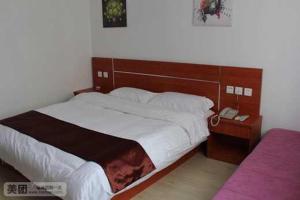 um quarto com uma cama grande e um telefone em Thank Inn Chain Hotel Jiangsu Yancheng Jianhu Guanhua Road em Jianhu