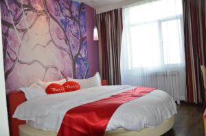 金昌市にあるThank Inn Chain Hotel Gansu Jinchang Heya Roadのベッドルーム1室(大型ベッド1台、赤と白の枕付)