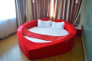 Sofá rojo con cama blanca en una habitación en Thank Inn Chain Hotel Hebei Cangzhou Qing County Nanhuan Road en Qing