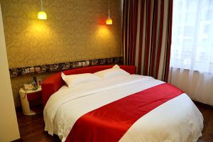 a red and white bed in a hotel room at Thank Inn Chain Hotel Liaoning Anshan Haicheng Wanda in Yanjun