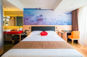 Un dormitorio con una cama con una almohada roja. en Thank Inn Plus Hotel Shandong Qingdao Development Zone Xiangjiang Road Changjiang Shopping Mall en Yen-t'ai-ch'ien