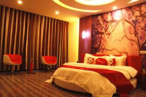 een hotelkamer met een bed en twee stoelen bij Thank Inn Chain Hotel Huebei Jinmen Jingshan County Chengzhong Road in Jingshan