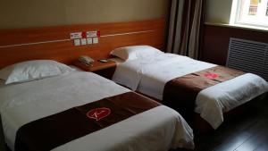 een hotelkamer met 2 bedden en een raam bij Thank Inn Chain Hotel Shanxi Lvliang County Taihe North Road in Houganquan