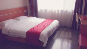 1 dormitorio con 1 cama con manta roja y blanca en Thank Inn Chain Hotel Shanxi Lvliang Lishi Beichuanghe Road, en Luliang