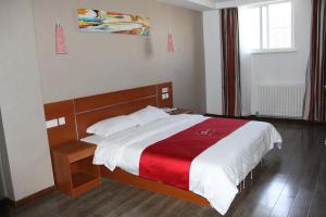 a bedroom with a bed with a red and white blanket at Thank Inn Chain Hotel Shandong Liaocheng Economic Development Zone Jiuhe Community in Liaocheng