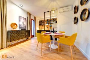 Un comedor con una mesa y sillas amarillas. en Azotea de la Catedral, en Toledo