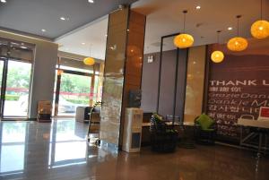 een lobby met een tafel en stoelen in een gebouw bij Thank Inn Shanxi Shuozhouying County West Jingcheng Street in Ying