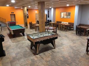 a room with a pool table and tables and chairs at Complejo Hotelero La Braña in San Isidro