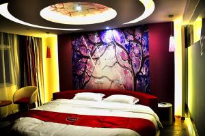 ein Schlafzimmer mit einem großen Bett und einem Gemälde an der Wand in der Unterkunft Thank Inn Chain Hotel Henan Xinyang Shangcheng County Huayuan Road in Shangcheng