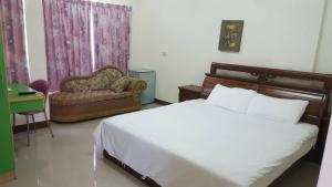 une chambre avec un lit, une chaise et un canapé dans l'établissement Dong Wang Homestay, à Taïtung