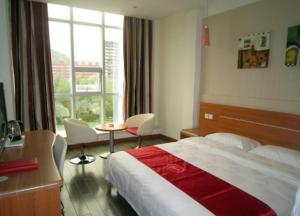 een hotelkamer met een bed, een bureau en een raam bij Thank Inn Chain Hotel Shanxi Lvliang Lishi Beichuanghe Road in Luliang
