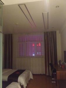 a bedroom with a bed and a window with red lights at Thank Inn Chain Hotel Hebei Langfang the 6th Street in Langfang