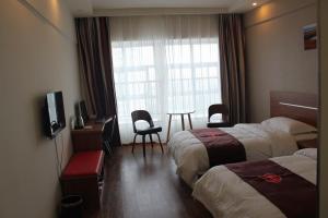 a hotel room with two beds and a table and a window at Thank Inn Chain Hotel Hubin District Dongfeng Market in Sanmenxia